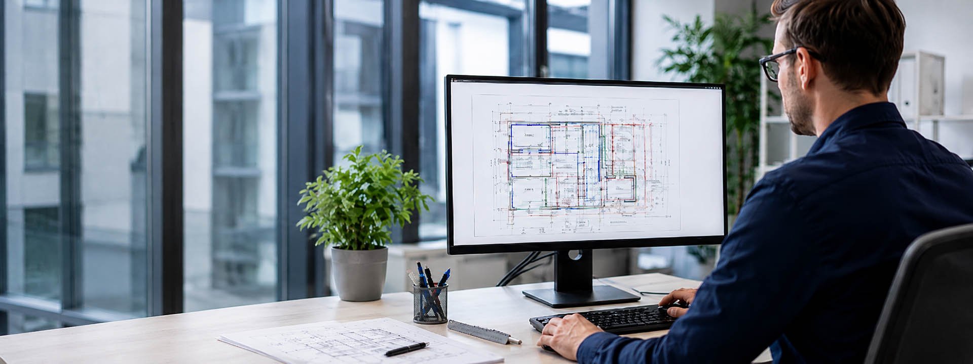 Ingenieur plant technische Geb&auml;udeausr&uuml;stung am Computer mit Bauplan f&uuml;r Heizung, Sanit&auml;r, L&uuml;ftung und Elektrotechnik