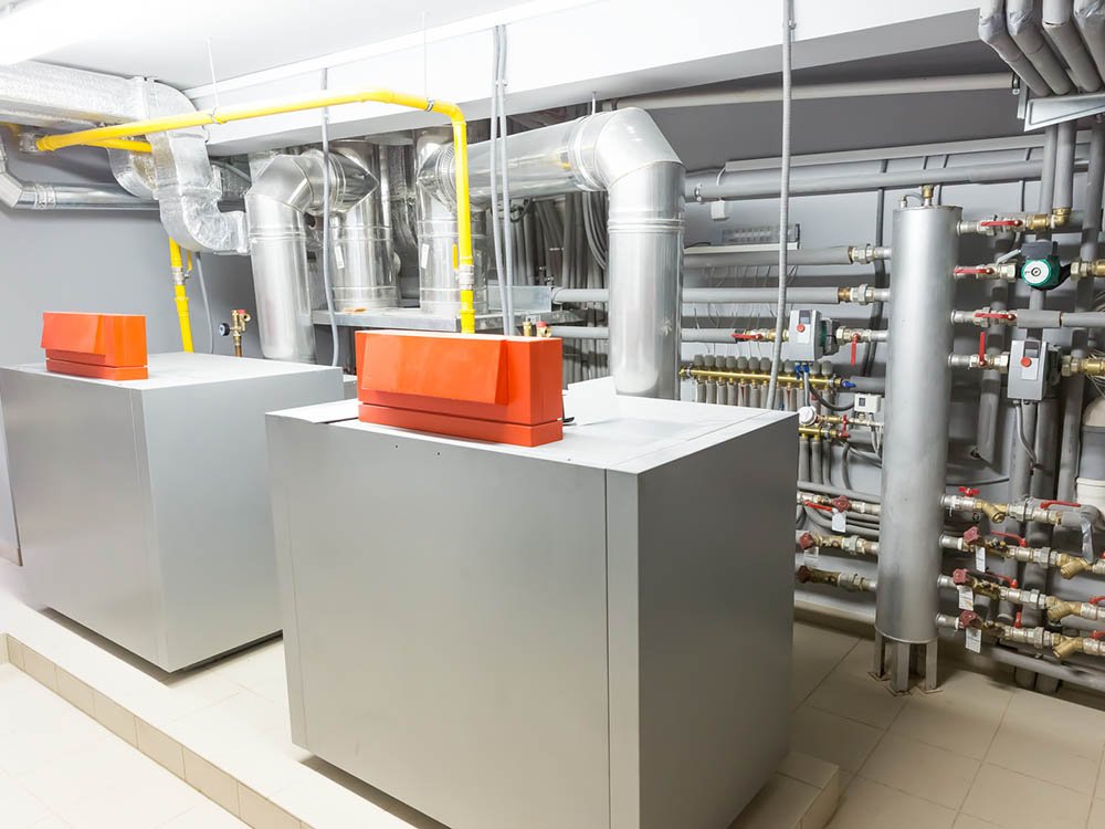 Technikraum mit Heizungsanlage und Lüftungstechnik Technikraum mit Heizungsanlage, Lüftungskanälen und Rohrleitungen für technische Gebäudeausrüstung im Gewerbegebäude